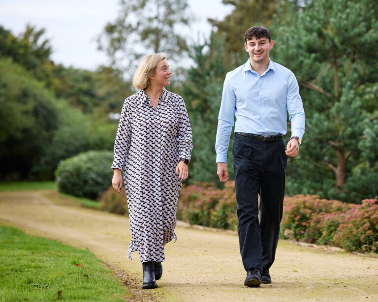 Sophie and Lewis walking in the garden surrounding the Marmion office